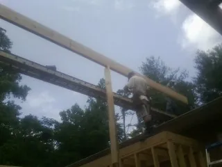 Carpenter setting a ridge beam over a new addition frame — Ice Dam Removal by Roofing Brothers in San Juan Bautista